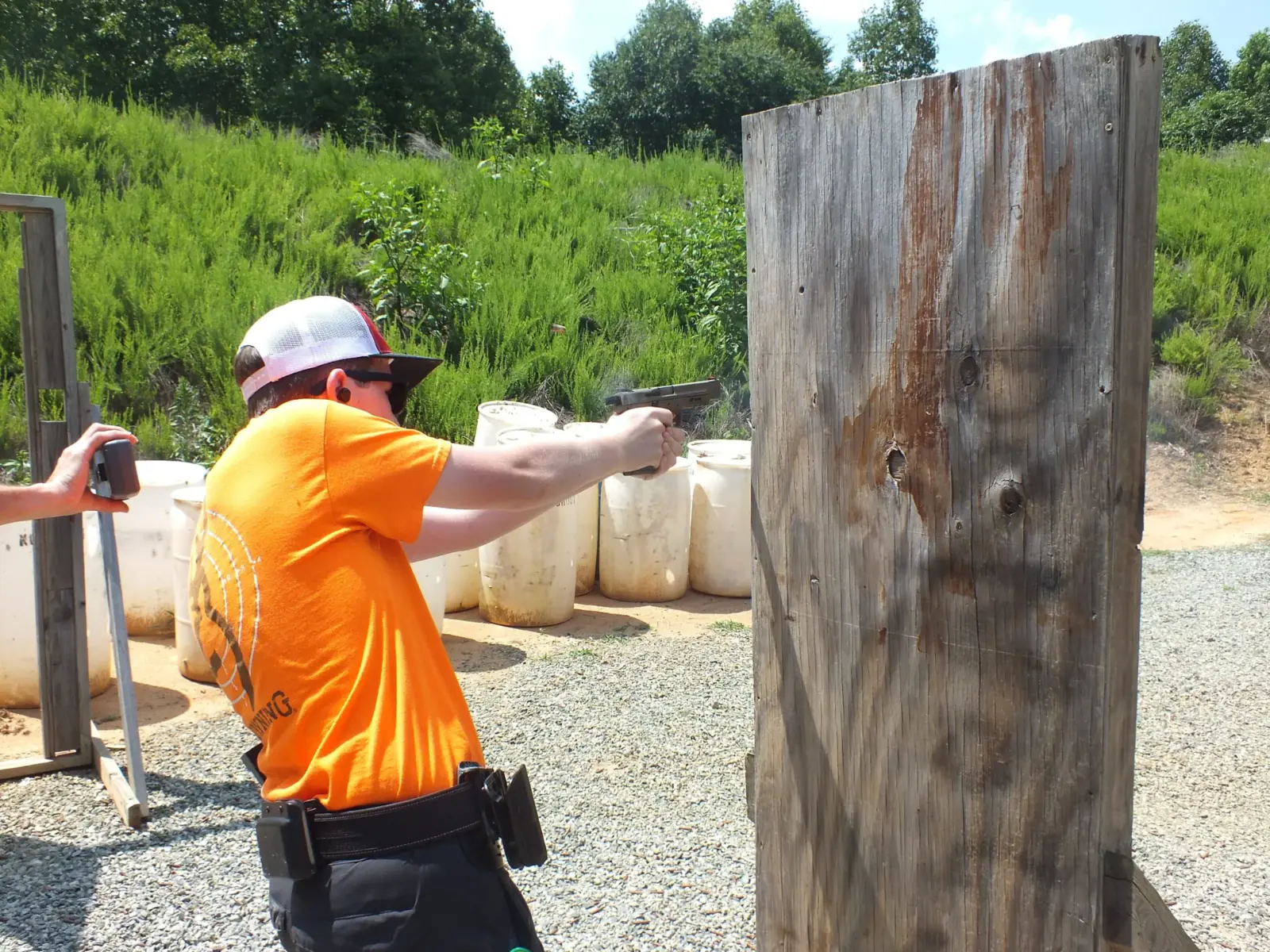 A shooter practicing defensive pistol skills from cover at Lewis Creek Shooting School