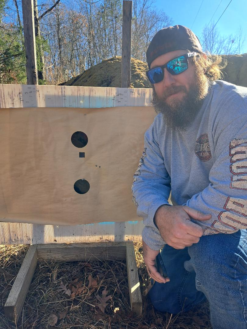 A shooter beside a paper target at Lewis Creek