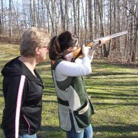 A shooter practicing wingshooting with an instructor alongside